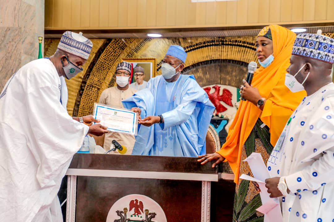 Ganduje presenting certificate to one of the students