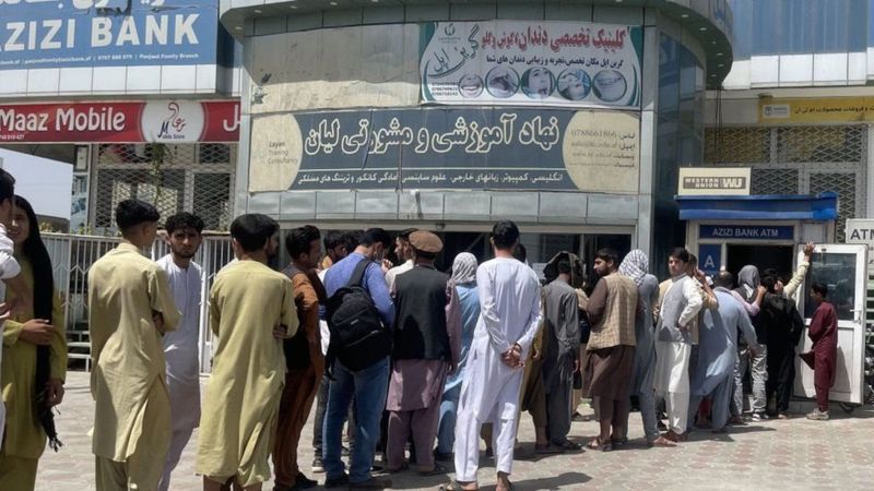 People line up at the door of AZIZI Bank to collect their deposits amid financial crisis in Kabul