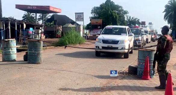 A soldier stops a car approaching a checkpoint in Nnewi.